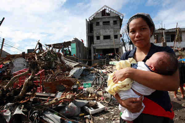A woman and her baby amid debris and other destruction caused by Super Typhoon Haiyan in the Philippines. Photo: UNICEF / Jeoffrey Maitem
