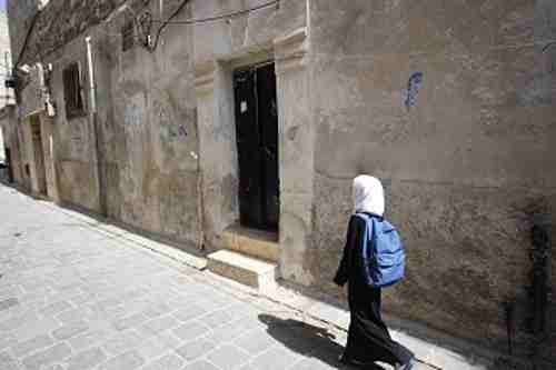 In eastern Aleppo, a young girl returns home from school.