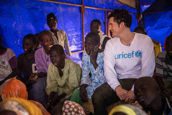 UNICEF Goodwill Ambassador Orlando Bloom (right) sits with displaced adolescents as they attend a literacy class for those who have no prior formal education in Garin Wazam camp, located 54 kilometres from Diffa town, Niger, Thursday 18 February 2017. The class aims to help the students transition into a regular education programme.
