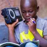 In Rwanda, a boy listens to a radio. Photo: UNICEF