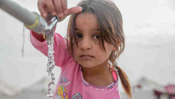 A young girl from Mosul takes water from a tap stand at a UNICEF-supported Temporary Learning Space in Hassan Sham Displacement Camp, Ninewa Governorate. Photo: UNICEF (Representational image)
